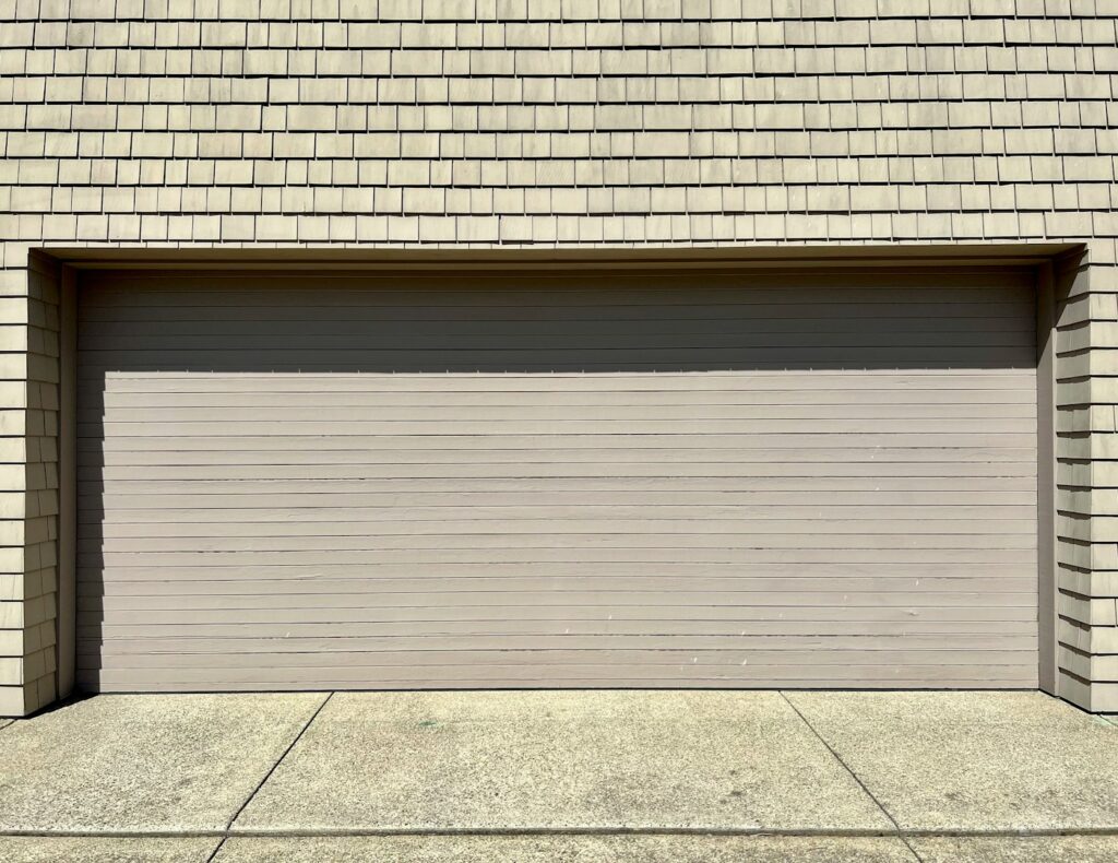 Garage door torsion spring mounted above the door under tension