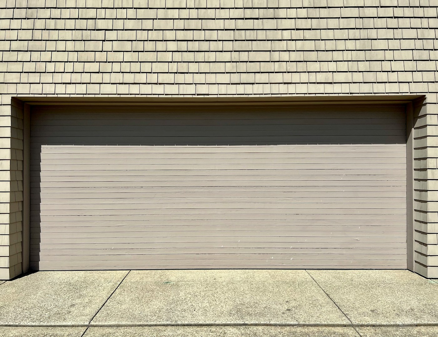 Garage door torsion spring mounted above the door under tension
